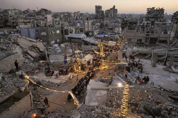 Palestinians gather for iftar, the fast-breaking meal, during the Muslim holy month of Ramadan amid the rubble of destroyed buildings in Gaza City, Sunday, Feb. 22, 2026. (AP Photo/Jehad Alshrafi)