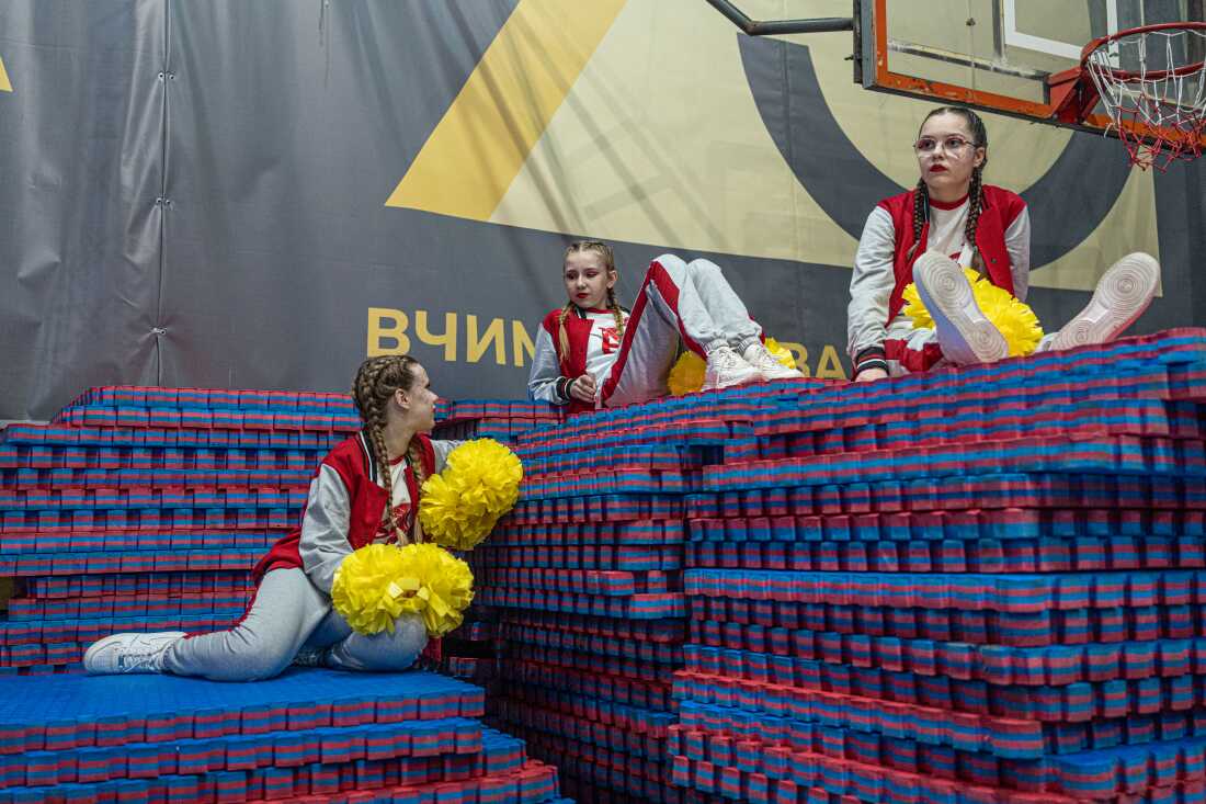 Young cheerleaders sit around at Kyiv's Ukraine Cheer Cup competition. Sunrise is the only team in the over-25 age group.
