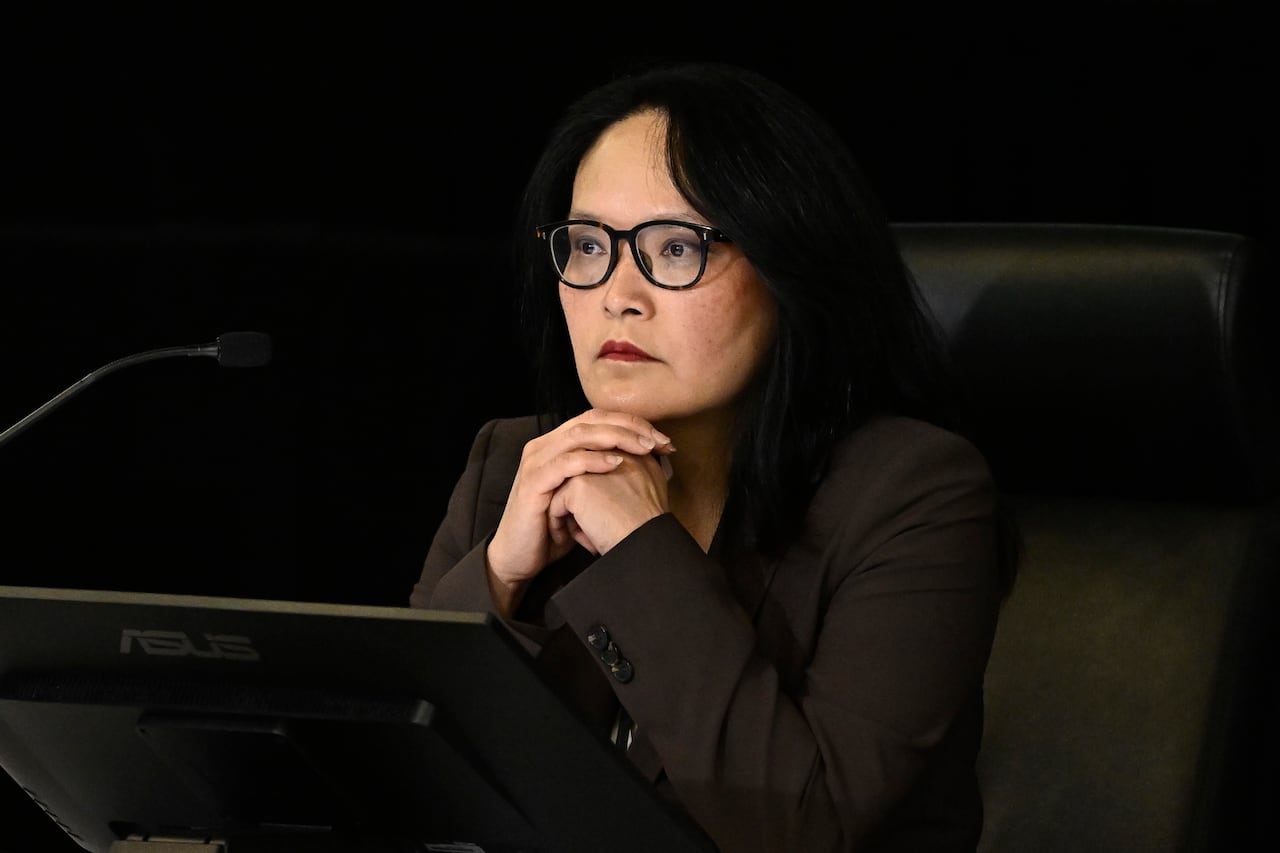 A woman sits at a desk.