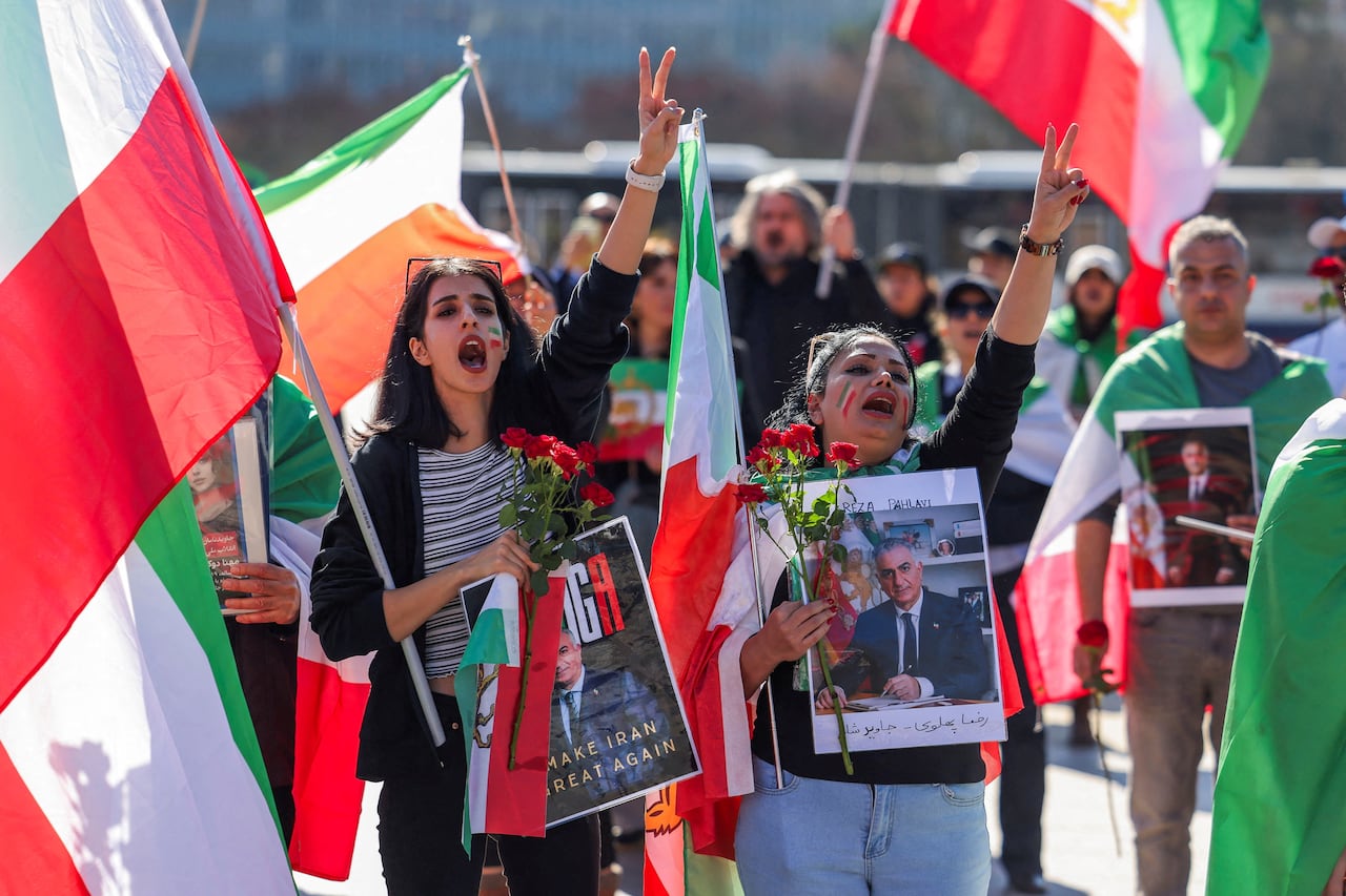 Demonstrators hold images of a man as they hold a protest on a street.
