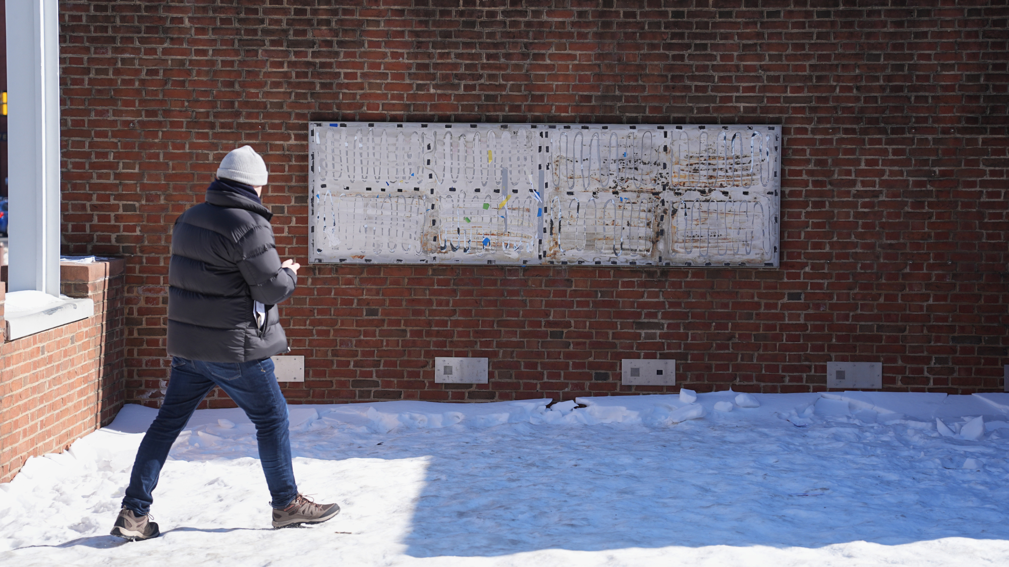 A person moves to photograph the location of the now removed explanatory panels that were part of an exhibit on slavery at President's House Site in Philadelphia, Jan. 30, 2026.