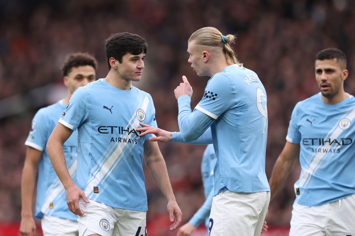 MANCHESTER, ENGLAND - JANUARY 17: Erling Haaland of Manchester City speaks with Abdukodir Khusanov of Manchester City during the Premier League match between Manchester United and Manchester City at Old Trafford on January 17, 2026 in Manchester, England. (Photo by Copa/Getty Images)