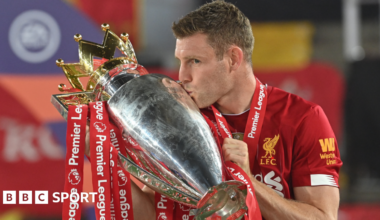 Liverpool's James Milner kisses the Premier League trophy in 2020