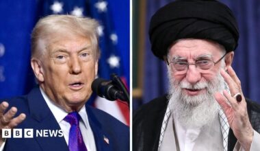 Two women and a man walk past a billboard showing an artistic impression of clouds in the red, white and blue colours of the US flag. Slogans appear on the billboard in Farsi and English.