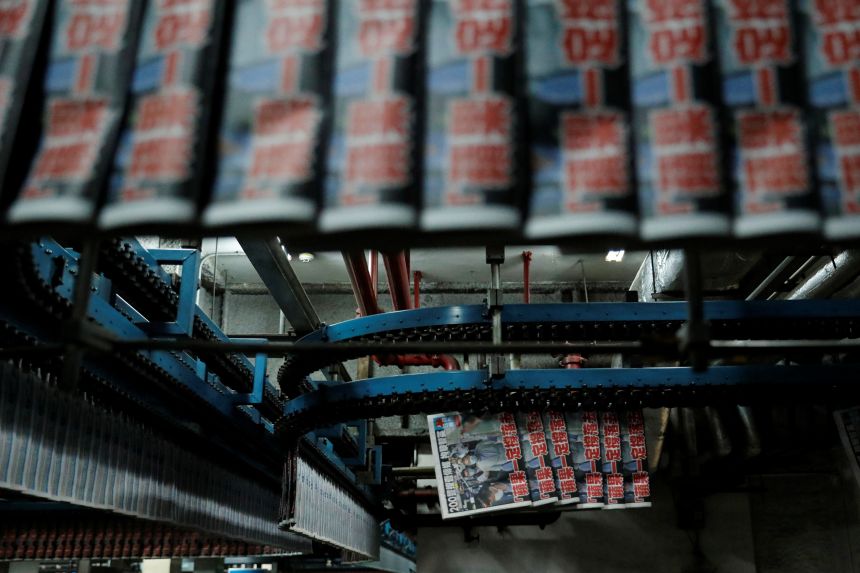 Copies of the Apple Daily newspaper, published by Next Media Ltd, with a headline 