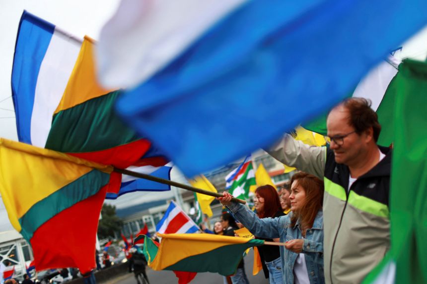 People wave flags ahead of Sunday's elections, with polls indicating Laura Fernandez of the Sovereign People's Party as the clear frontrunner, amid a surge in drug trafficking and violence that has eroded the country's image as a peaceful tourist haven.