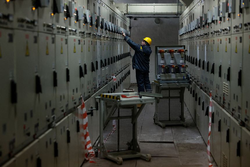 Oleksandr Zinchenko, 36, an employee of an energy company, deals with an issue with voltage at a power substation after recent Russian drone and missile strikes, on February 5, 2026.