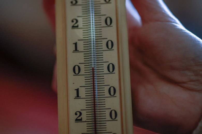Yuliia Davydenko shows a thermometer reading of just 3 degrees Celsius (about 37 degrees Fahrenheit) inside her family's apartment in Kyiv, which has no heating or hot water and experiences frequent power outages.