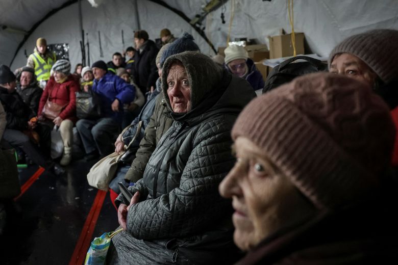 Residents wait for hot meals inside a tent at a government‑run humanitarian aid point, where people can warm up, charge their devices, get hot drinks and receive psychological support.