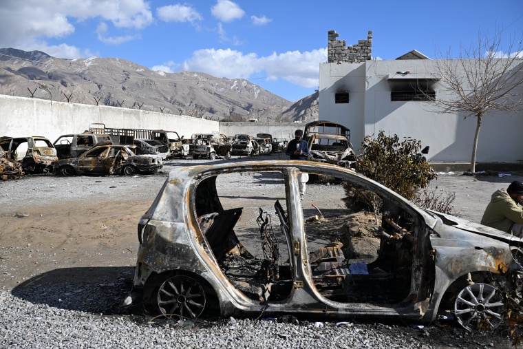 A man stands beside burnt vehicles inside a torched police station on the outskirts of Quetta on Feb. 1.