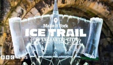 A sign carved from ice with the words Make it York Ice Trail An Enchanted City carved into the sign