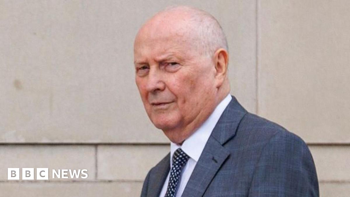 Frank Cushnahan, a man with short grey hair, wearing a grey suit, a white tie and dark tie with white dots.