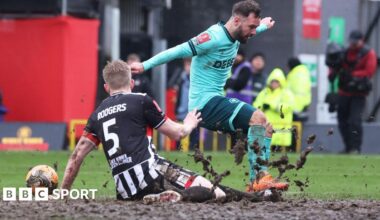 Wolves' Adam Armstrong attempts to meet a cross under pressure from Grimsby's Jackson Smith and Harvey Rodgers