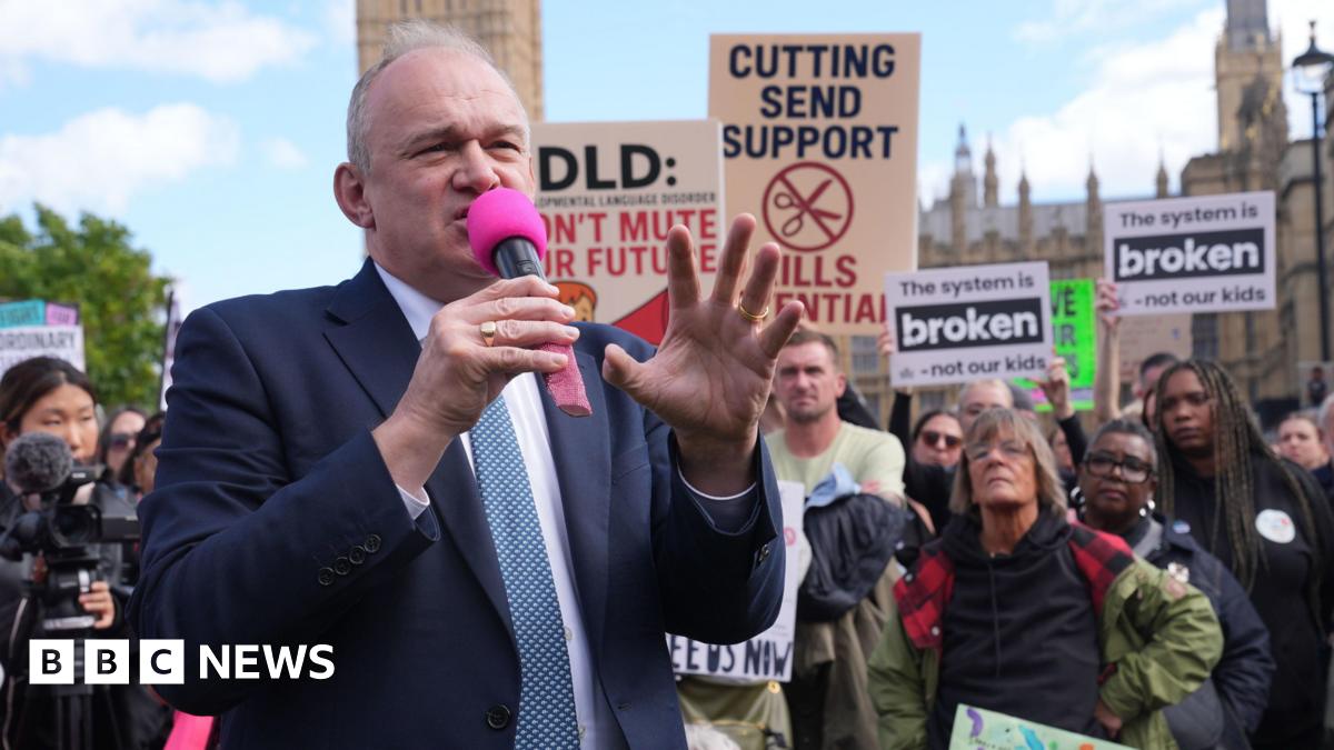 A fossil of part of a crinoid that resembles a row of teeth. The markings form a curved shape with pale, tooth‑like segments set against the darker surface of the fossil. The fossil rests on another rock in the foreground.