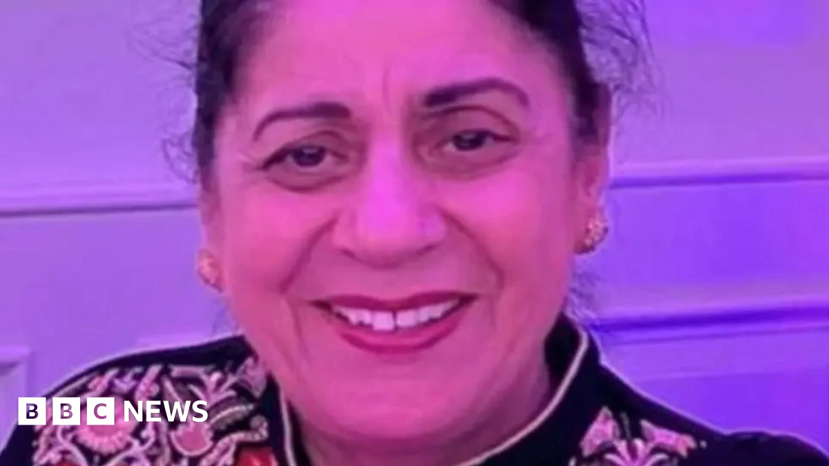 A picture of Pulvinder Dhillon, who has long hair tied back and is wearing gold earrings. She is smiling for the camera.