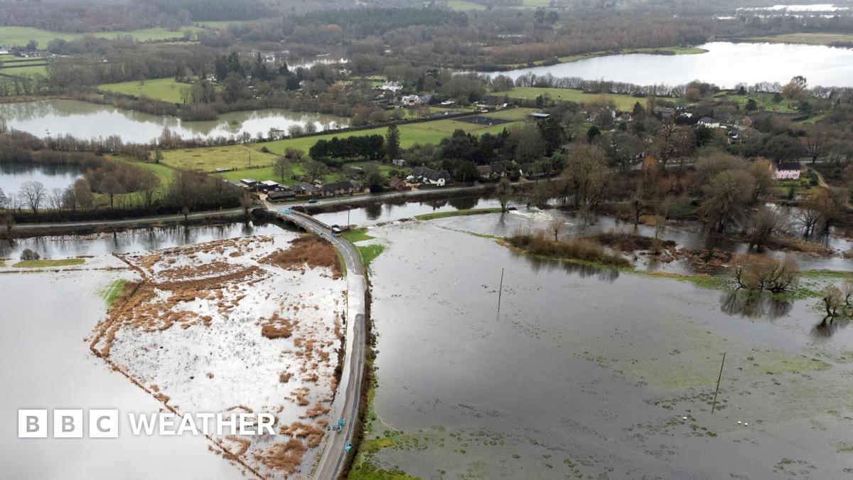 An aerial image shows a flooded road surrounded by standing water in a rural setting with trees, greenery and more floodwater in the background, in Hampshire on Friday.