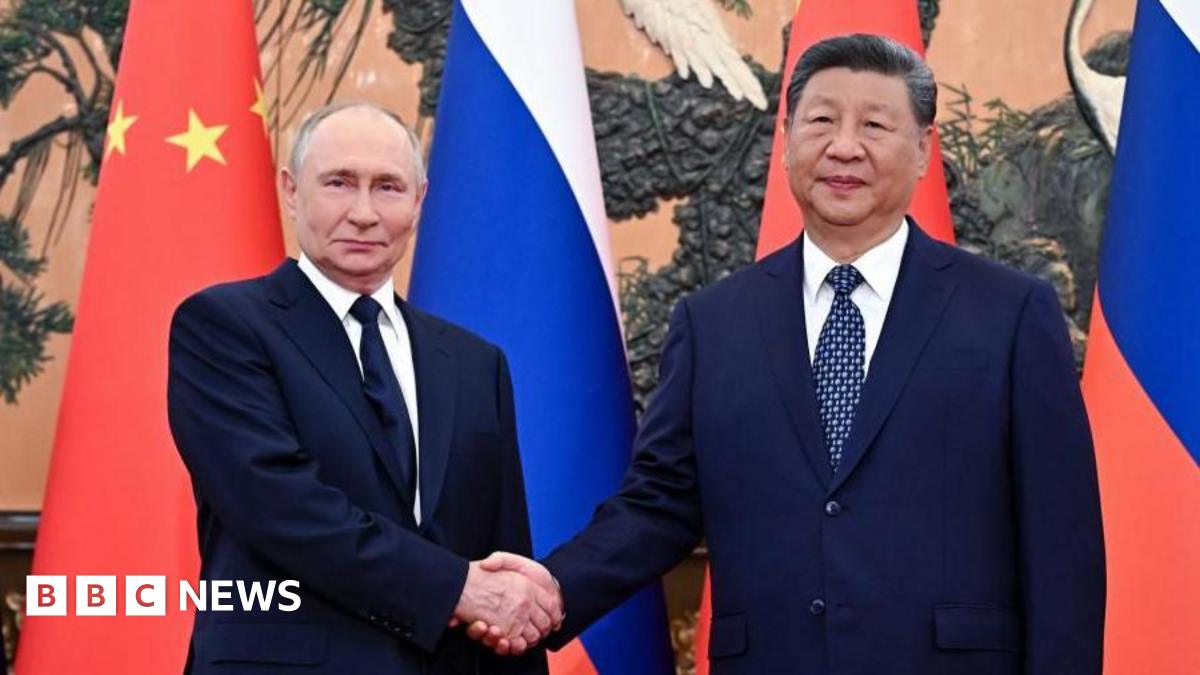 Vladimir Putin and Xi Jinping shake hands, with the flags of Russia and China in the background