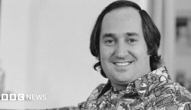 Neil Sedaka in a black and white photo wearing a 1970s style shirt