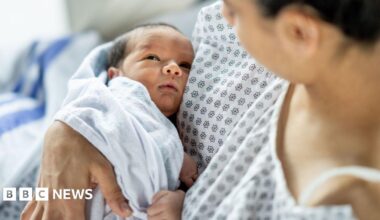 A mother holds her newborn baby in hospital