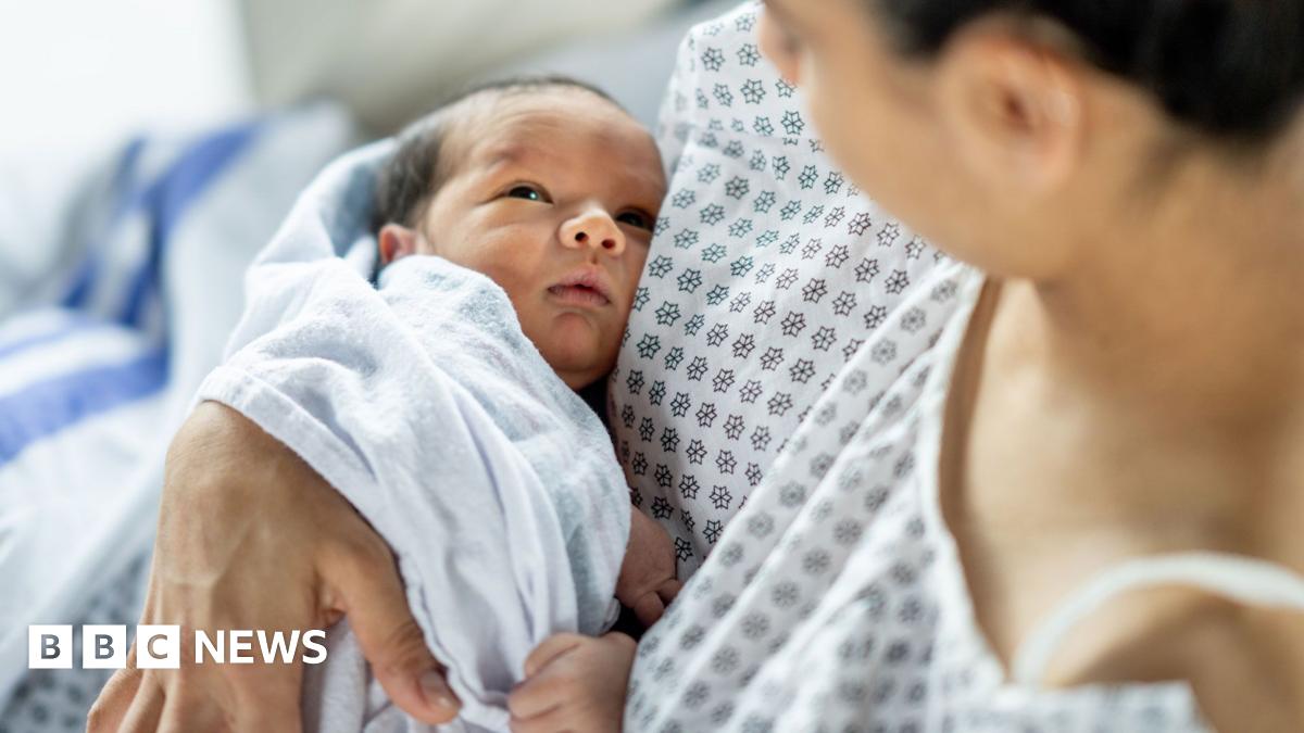 A mother holds her newborn baby in hospital