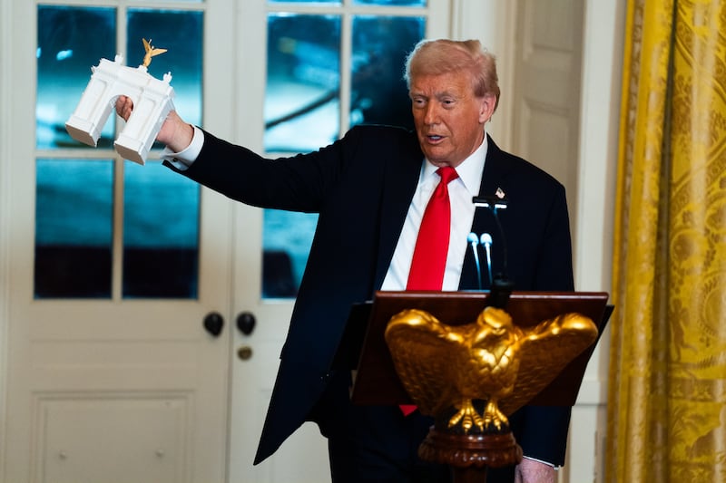 WASHINGTON, DC  October 15: US President Donald Trump holds up a model of an arch while delivering remarks during a ballroom fundraising dinner in the East Room of the White House on Wednesday October 15, 2025. (Photo by Demetrius Freeman/The Washington Post via Getty Images)