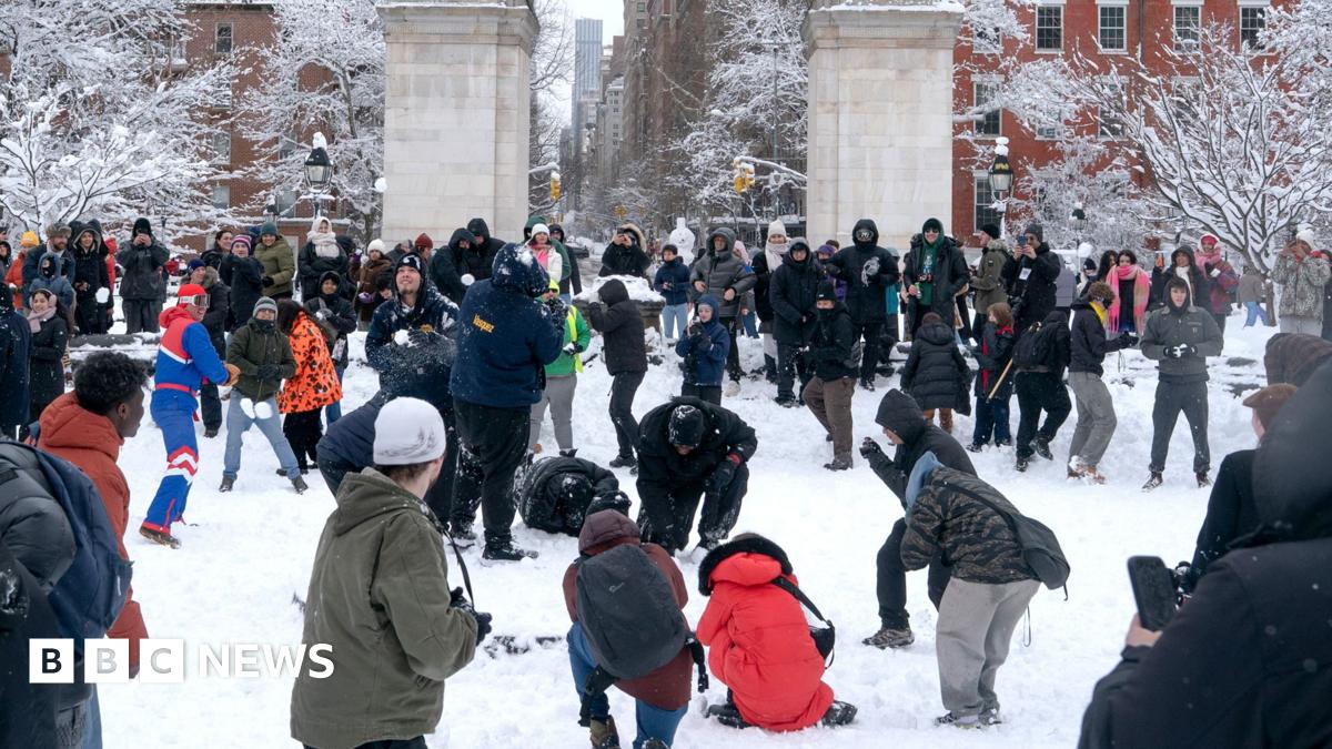 Dozens of people play and throw snowballs in New York's Washington Square Park