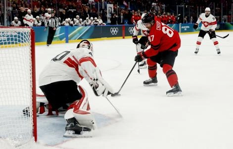Feb 13, 2026; Milan, Italy; Sidney Crosby of Canada in action with Akira Schmid of Switzerland in men's ice hockey group A play during the Milano Cortina 2026 Olympic Winter Games at Milano Santagiulia Ice Hockey Arena.