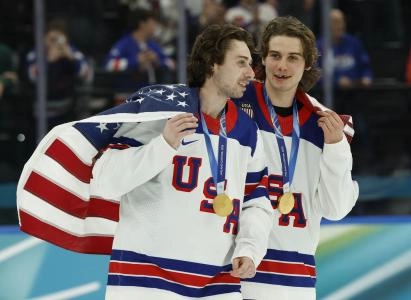 Feb 22, 2026; Milan, Italy; Quinn Hughes (43) of the United States and Jack Hughes (86) of the United States celebrate after defeating Canada in the men's ice hockey gold medal game during the Milano Cortina 2026 Olympic Winter Games at Milano Santagiulia Ice Hockey Arena. Mandatory Credit: Geoff Burke-Imagn Images