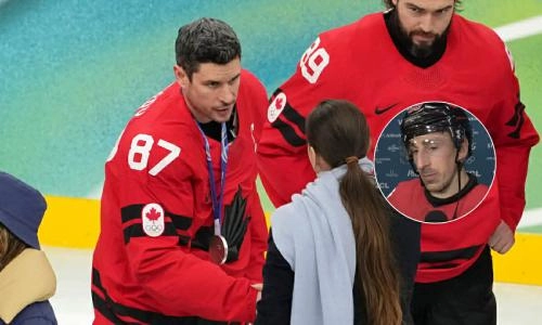 Feb 22, 2026; Milan, Italy; Sidney Crosby of Canada receives his silver medal in the men's ice hockey gold medal game during the Milano Cortina 2026 Olympic Winter Games at Milano Santagiulia Ice Hockey Arena; Brad Marchand also featured (right) Mandatory Credit: James Lang-Imagn Images