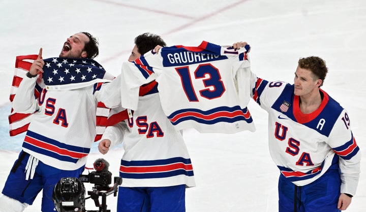 U.S. players hold up the jersey of their late teammate, Johnny Gaudreau, following the squad's gold medal win in Milan.