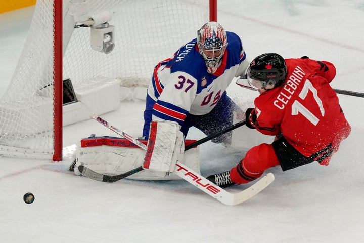 Team USA's Connor Hellebuyck (left) makes a save on a shot by Canada's Macklin Celebrini (right) during the third period of the men's ice hockey gold medal showdown at the Winter Olympics on Sunday.