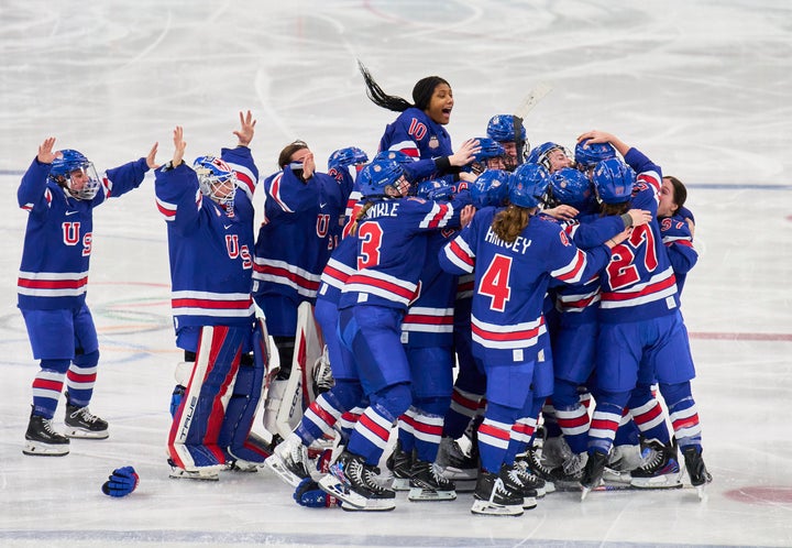 Members of Team USA women's ice hockey celebrate Megan Keller's game-winning overtime goal against Canada at Milano Santagiulia Ice Hockey Arena on Thursday.