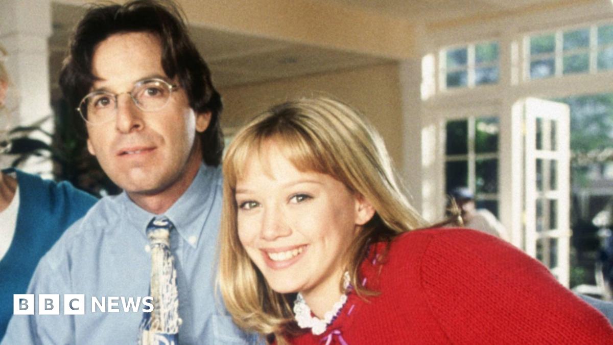 Robert Carradine attends the ceremony honouring Burt Ward with A Star on the Hollywood Walk of Fame held on 9 Januray 2020 in Hollywood, California. He has shoulder-length grey hair and goatee beard and is wearing a black shirt and black glasses.