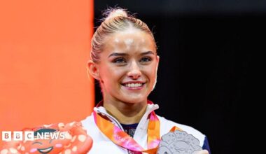 Headshot of Georgia Evans. Her hands framing her face