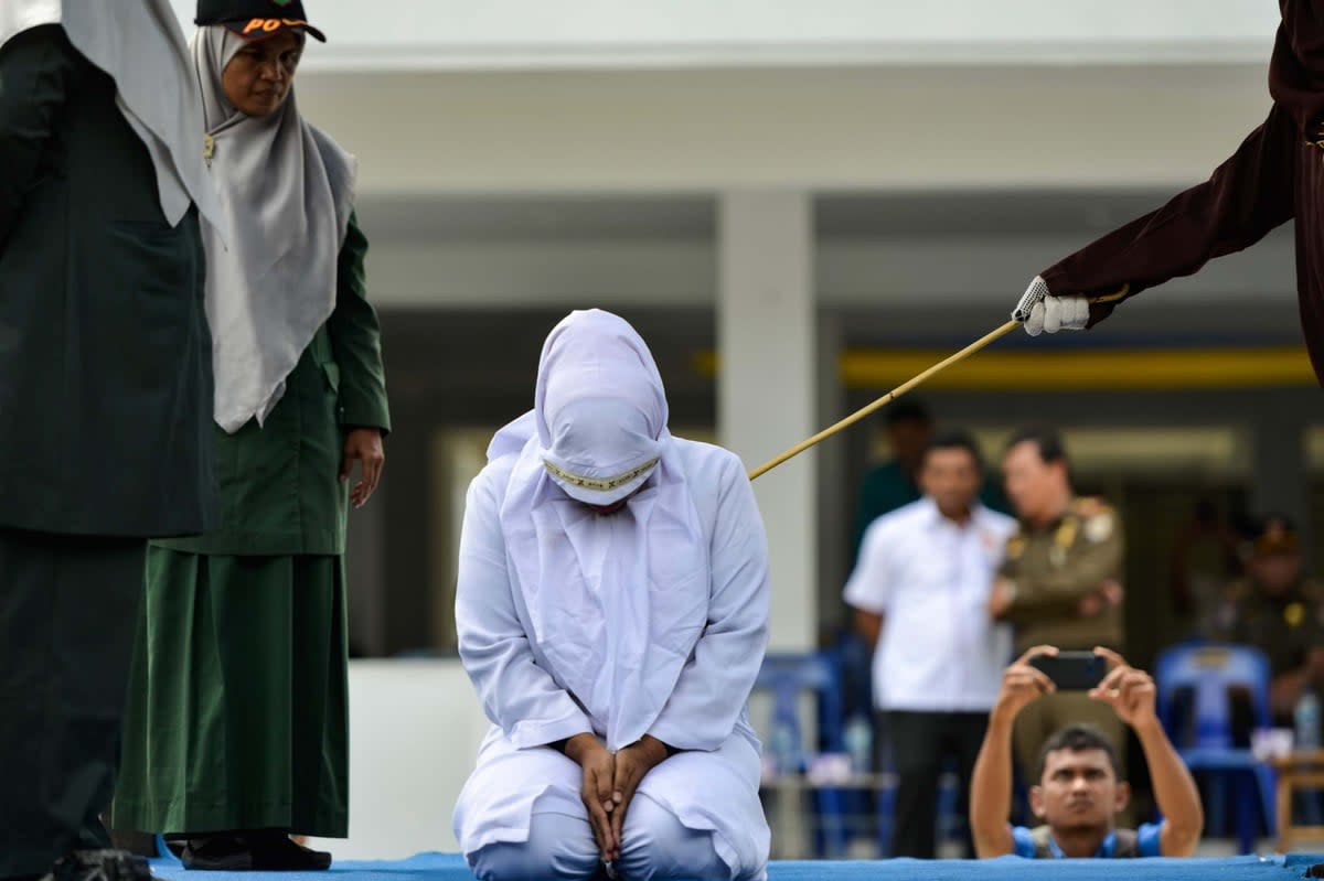 A woman whipped in public by a member of the sharia police in Indonesia in October 2019 (AFP via Getty Images)