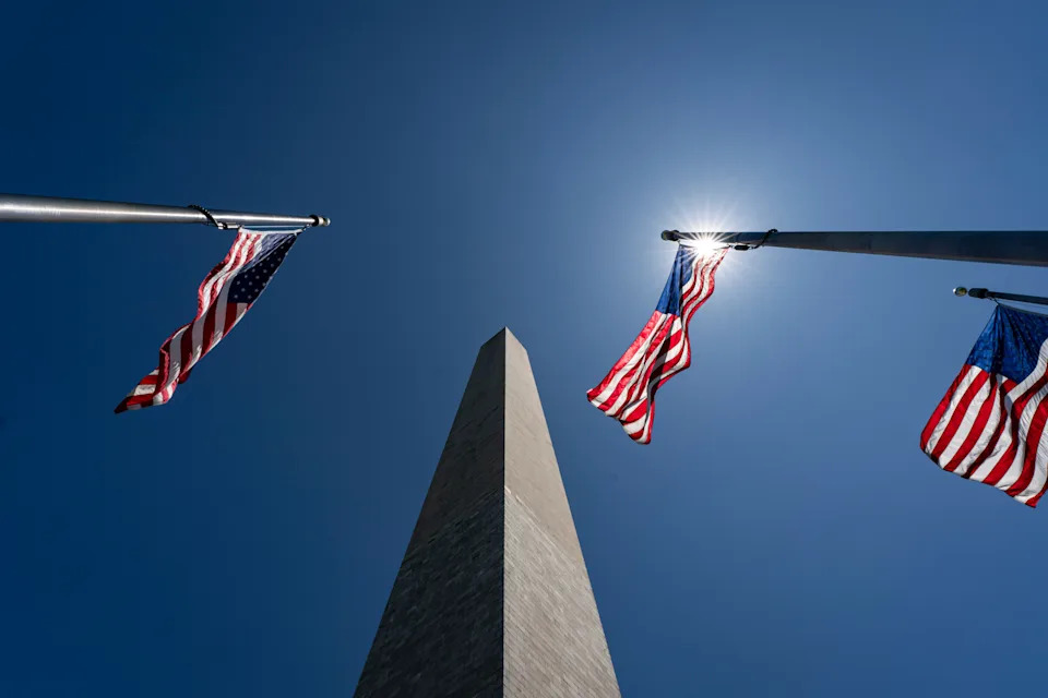 The Washington Monument between American flags in Washington, DC, US. Photographer Al Drago/Bloomberg