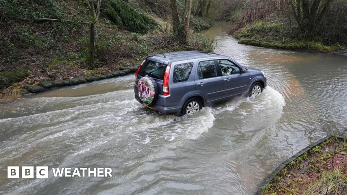 A blue SUV drives through a flooded road in Houndsfield Lane, Birmingham, on Monday.