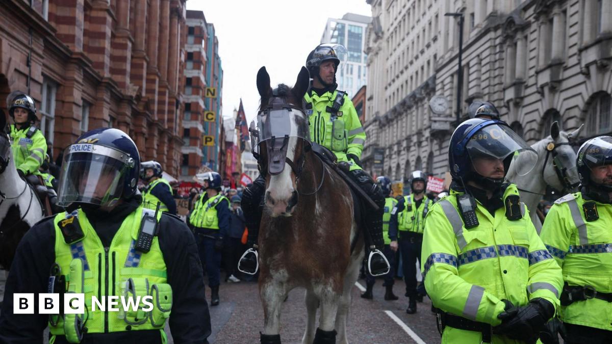 A police officer rides a horse, as protesters take part in the Britain First march in Manchester