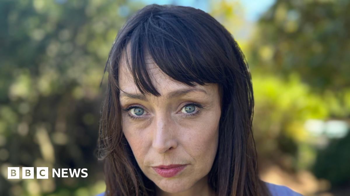 Juliette Bryant, now aged 43, has long brown hair with a fringe and stands outside with a serious expression
