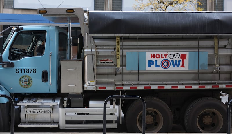 A sign on a Streets and Sanitation snowplow parked in Chicago's Loop reads "Holy Plow,"