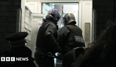 Two GMP officers batter down the door of one address during the raids. They've heavily clothed and both hold an instrument designed to open the front door.