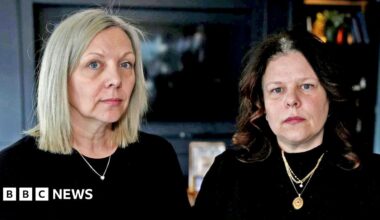 A fossil of part of a crinoid that resembles a row of teeth. The markings form a curved shape with pale, tooth‑like segments set against the darker surface of the fossil. The fossil rests on another rock in the foreground.