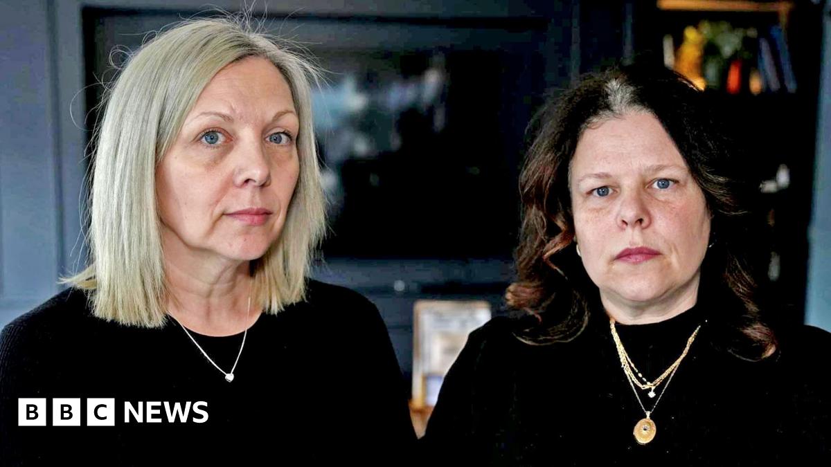 A fossil of part of a crinoid that resembles a row of teeth. The markings form a curved shape with pale, tooth‑like segments set against the darker surface of the fossil. The fossil rests on another rock in the foreground.