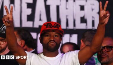 Floyd Mayweather raises his hands in the air during a  weigh-in