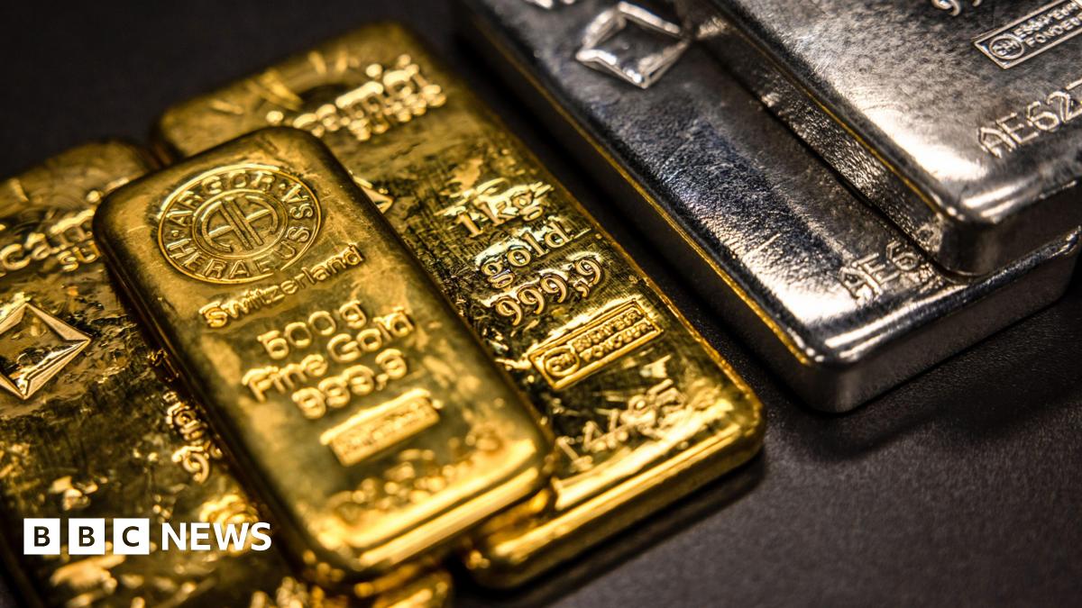 One kilogram and a five hundred gram gold bars next to one kilogram silver bars at The Vaults Group gold dealers.