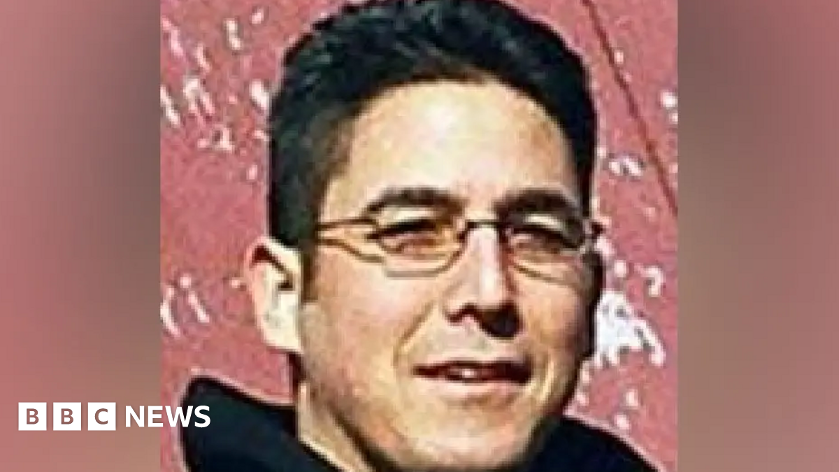 Close up of Daniel Andreas San Diego shortly after he went on the run in 2003. Shows San Diego, who is no 47, with close cropped short black hair and narrow rectangle wire rimmed glasses.