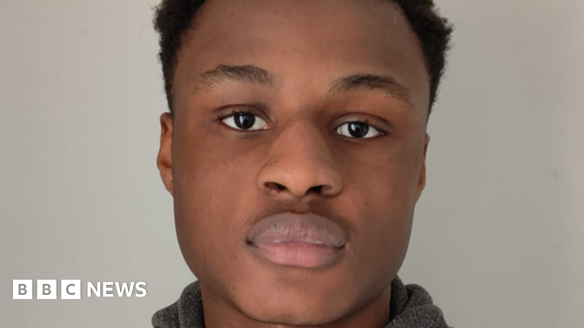 Michael Ababio, with dark hair, is looking at the camera. He is pictured in front of a grey background.