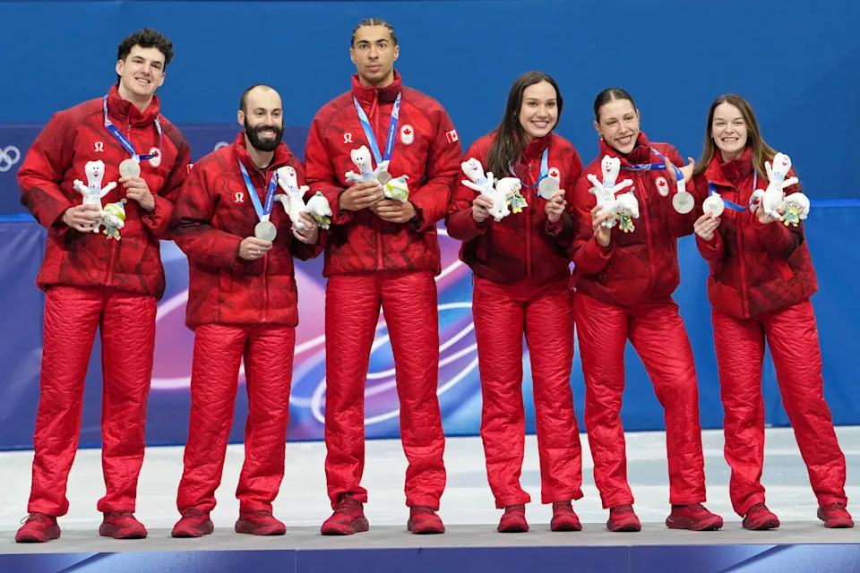 Feb 10, 2026; Milan, Italy; Silver medalists Canada stands on the podium during the medal ceremony for the mixed team relay during the Milano Cortina 2026 Olympic Winter Games at Milano Ice Skating Arena. Mandatory Credit: James Lang-Imagn Images