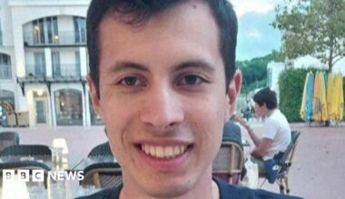 A  young man called Quentin Deranque sits outside