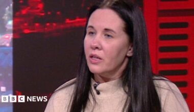 Sharon with long dark hair wearing a cream jumper in the BBC North West Tonight studio.